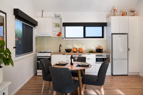 a kitchen with a table and chairs in a kitchen at Cosy Edge- charming studio on edge of town in Daylesford