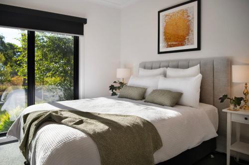 a bedroom with a large bed and a large window at Cosy Edge- charming studio on edge of town in Daylesford