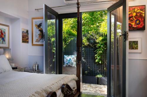 een slaapkamer met een bed en een glazen schuifdeur bij The Art Retreat in Daylesford