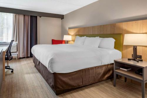 a hotel room with a large bed and a desk at Comfort Inn & Suites Liverpool - Syracuse North in Liverpool