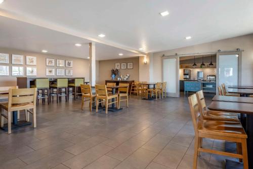 ein Esszimmer mit Tischen und Stühlen und eine Küche in der Unterkunft Comfort Inn & Suites Liverpool - Syracuse North in Liverpool