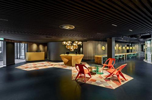 a lobby with two red chairs and a table at The Florian Amsterdam Schiphol Airport, WorldHotels Crafted in Hoofddorp