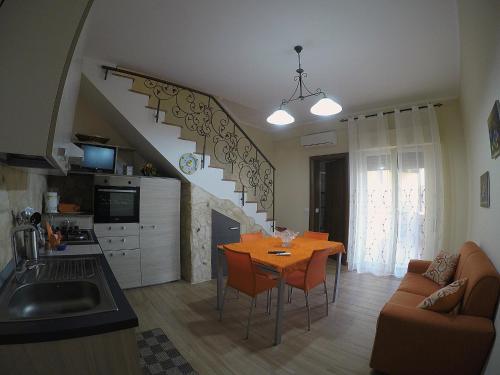 a kitchen and living room with a table and a staircase at Holiday Home Luppinedda in Nunziata