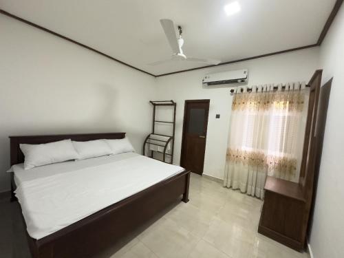 a bedroom with a bed and a window at Minhas Villas Guest in Kamburugamuwa