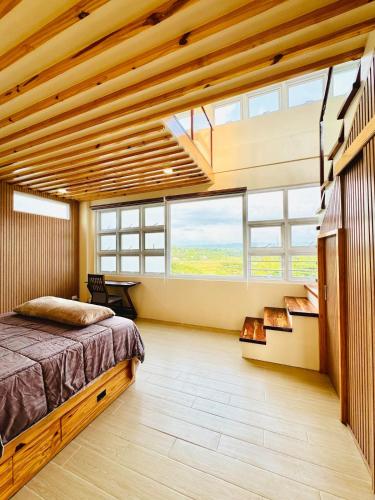 a bedroom with a bed and large windows at Dylan's Penthouse in San Fernando