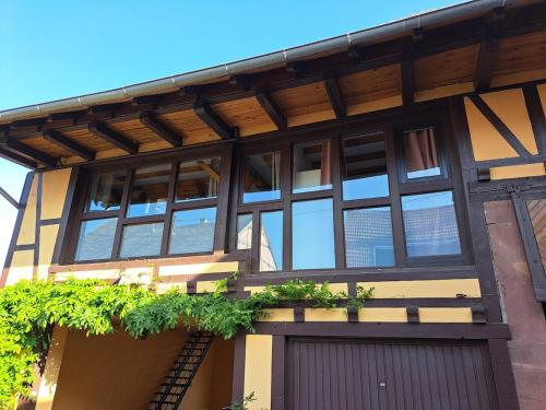 a building with a lot of windows and a garage at L'Horizon du Vignoble in Wangen