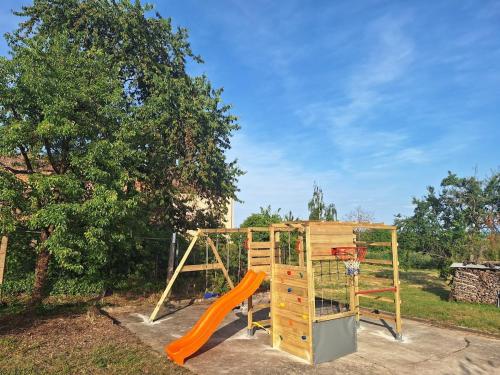 a playground with an orange slide and a basketball hoop at L'Horizon du Vignoble in Wangen