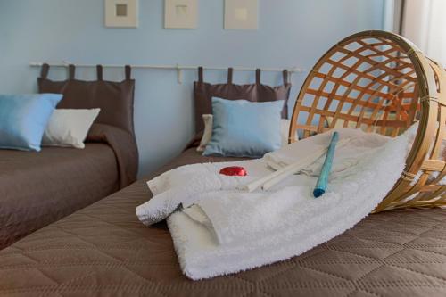 a room with a bed with a towel and a chair at L'Approdo in San Leone