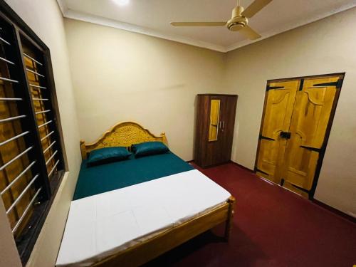 a bedroom with a bed and a wooden door at Right Choice House in Vaddakkachchi