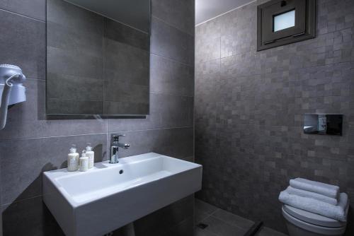 a bathroom with a white sink and a toilet at Casa Bianca Adults Only "by Checkin" in Hersonissos