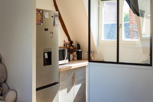 une cuisine avec un réfrigérateur blanc et une fenêtre dans l'établissement Appartement dans l'hypercentre de Rouen, à Rouen