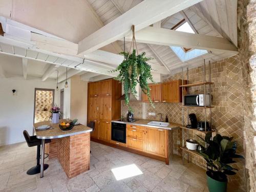 eine Küche mit Holzschränken und einem Tisch darin in der Unterkunft La Parent'eizh plein centre-ville 2p in Auray