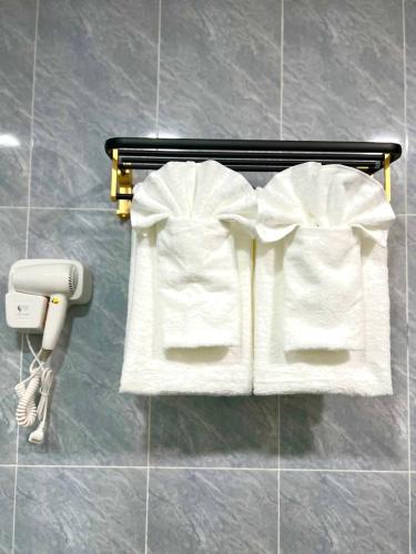 a couple of white towels on a rack in a bathroom at Palace Suite Residence in Phnom Penh