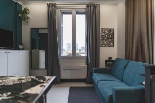 a living room with a blue couch and a window at WowNavigli Apartment-Sofa Bed Metro M4 Tram 2 in Milan