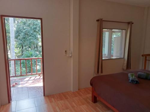 a bedroom with a bed and a door to a balcony at KPG Baan Tai 2 in Ban Tai