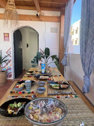 uma mesa com pratos de comida em cima em Arima Surf House em Tamraght Ouzdar