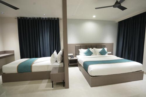 a bedroom with two beds and a ceiling fan at Hotel shree ji inn in Kishangarh