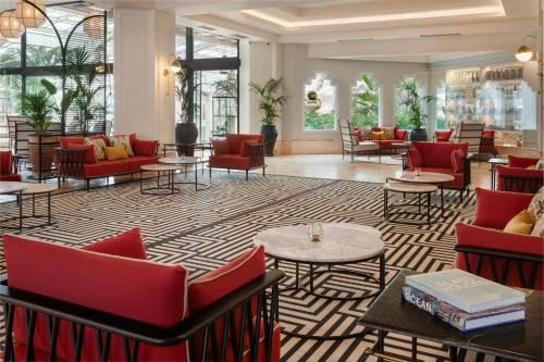 a lobby with red chairs and tables in a hotel at Meliá Isla Canela in Isla Canela