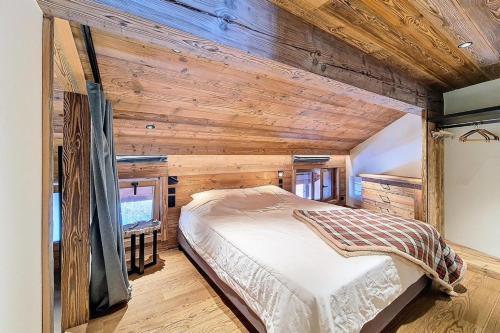 une chambre avec un lit dans une pièce aux murs en bois dans l'établissement Résidence Eperviere - Appartement en duplex lumineux · Au pied des pistes · Balcon MAE-0554, à Saint-Martin-de-Belleville