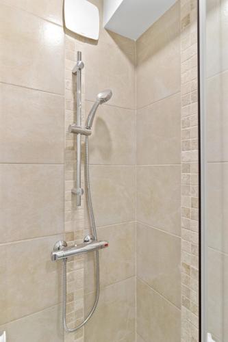 une douche dans une salle de bain avec une porte vitrée dans l'établissement Appartement Spacieux et Confort, à La Roche-sur-Yon