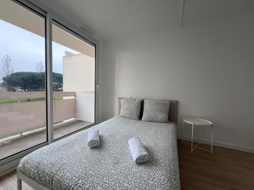 une chambre avec un lit et une grande fenêtre dans l'établissement Appartement Spacieux et Confort, à La Roche-sur-Yon