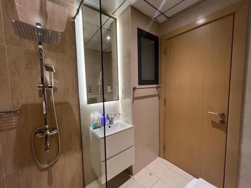 a bathroom with a shower and a glass door at Chic & Cozy Studio in JVC , Top Amenities & Views in Dubai