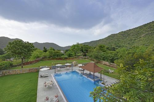 an overhead view of a swimming pool with mountains in the background at The Hunting Lodge - Luxury Resort in Udaipur in Udaipur