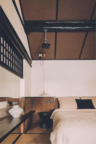 Postel nebo postele na pokoji v ubytování 以山屋舍izan国风禅意庭院 大理龙龛店