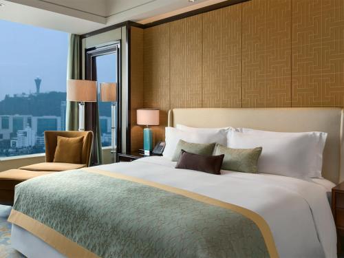 a bedroom with a large bed and a large window at Kempinski Hotel Xiamen in Xiamen