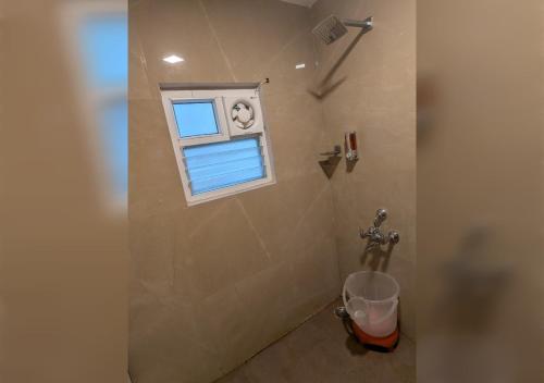 a bathroom with a toilet and a window at Mani's residency in Madurai