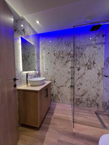 a bathroom with a sink and a glass shower at Adas Aura - Boutique Apartments in Old Town Thessaloniki in Thessaloniki