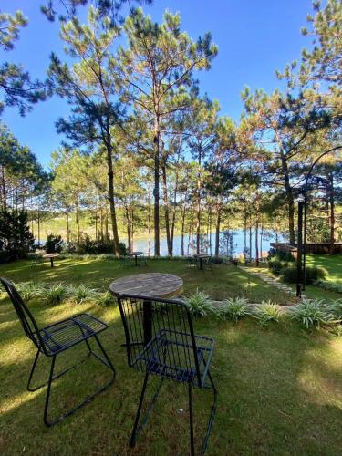 a table and chairs in a park with a view of the water at Romeo & Juliet Dalat in Da Lat