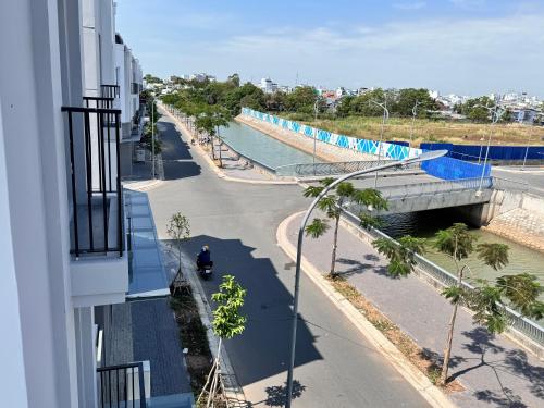 a person riding aooter on a street next to a bridge at Lá Riverside Boutique Hotel in Mỹ Phước