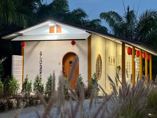 a small temple with red lanterns in a garden at สวนปาล์มการ์เด้นโฮม เชียงคาน Suanpalm Garden Home Changkhan in Chiang Khan
