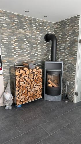 a fireplace with a pile of fire wood at Auszeit im Heinental in Wildberg