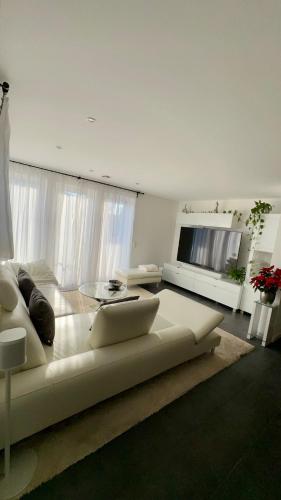 a living room with a white couch and a television at Auszeit im Heinental in Wildberg