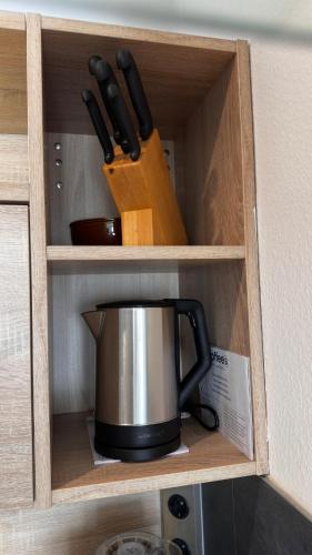 a cabinet with a coffee pot and knives in it at Auszeit im Heinental in Wildberg