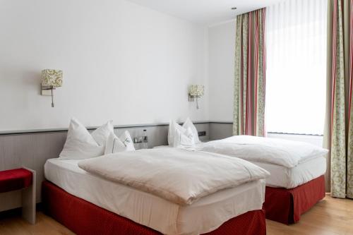 two twin beds in a room with a window at Hotel Coellner Hof in Cologne