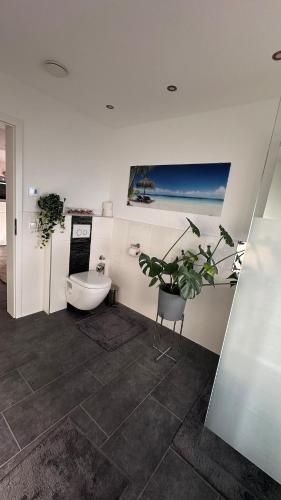 a bathroom with a toilet and a potted plant at Auszeit im Heinental in Wildberg
