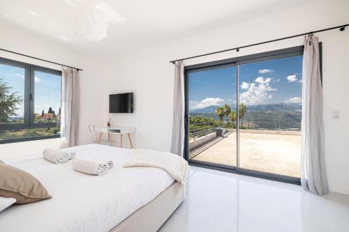 une chambre avec un lit et une grande fenêtre dans l'établissement VILLA CREMAT - Villa contemporaine - Piscine - Climatisation, à Nice