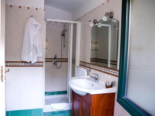a bathroom with a sink and a shower with a mirror at Ortigia L'Antico Dammuso in Syracuse