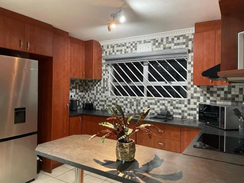 a kitchen with a table with a plant on it at Family friendly home in a cul-de-sac! in Muizenberg