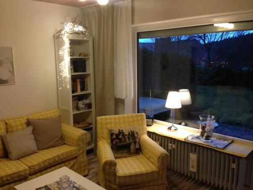 a living room with a couch and chairs and a window at Schwarzwaldhut in Häusern