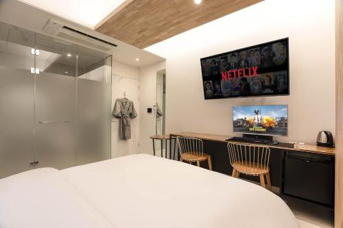 a bedroom with a bed and a desk with a tv at Hotel N in Seoul