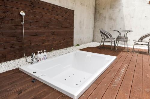a white bath tub sitting on a wooden deck at Hotel N in Seoul