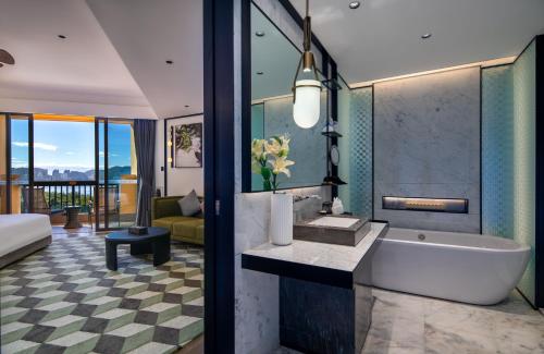 a bathroom with a tub and a sink in a room at Sanya Golden Phoenix Seaview Hotel in Sanya