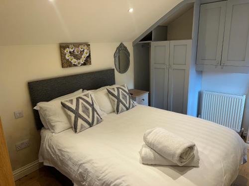 a bedroom with a large white bed with pillows at The Stable -Plymouth in Plymouth