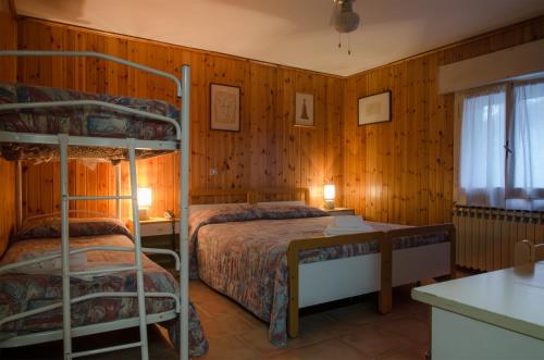 two bunk beds in a room with wooden walls at Hotel Capriolo in Vidiciatico