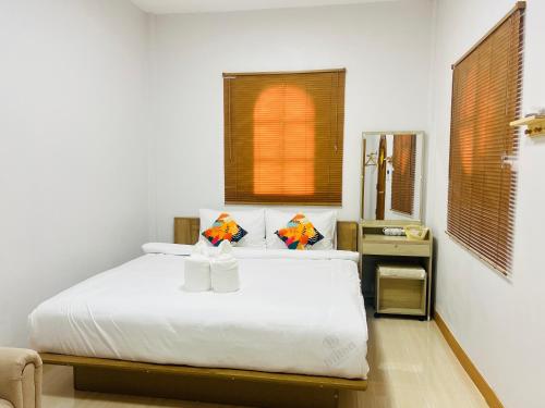 a bedroom with a white bed and a window at สวนปาล์มการ์เด้นโฮม เชียงคาน Suanpalm Garden Home Changkhan in Chiang Khan