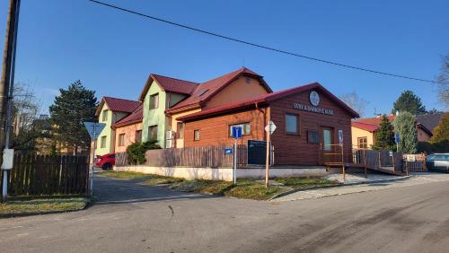 a wooden house on the side of a street at Penzion pod Bílou Horou in Kopřivnice